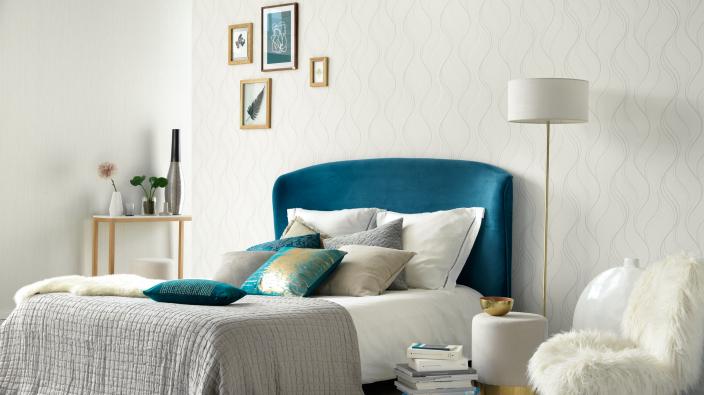 Wandgestaltung Schlafzimmer, weiße Vliestapete mit Wellenmuster, Bett blau, Dekokissen, Lampe