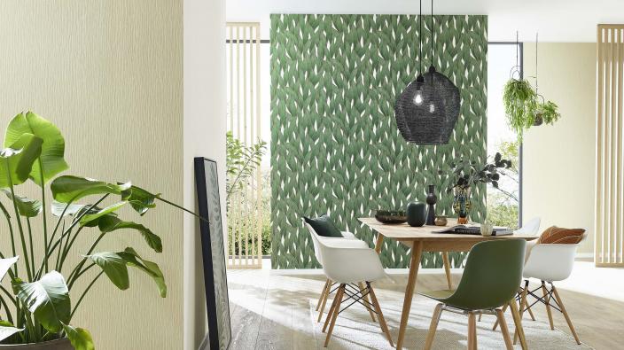 Modernes helles Esszimmer mit grüner Vliestapete mit Blattmuster, Esstisch und moderne Stühle