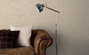 Vliestapete in kleinem grafischen Muster in Beige, Ledersofa braun und Stehlampe silber