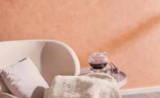 Vliestapete mit elegantem Marmor-Motive und metallsichen Effekten in einem frischen Apricot