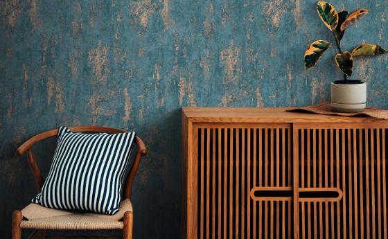 Vliestapete in Betonoptik türkis mit Metallic-Effekten, Sideboard und Stuhl aus Holz