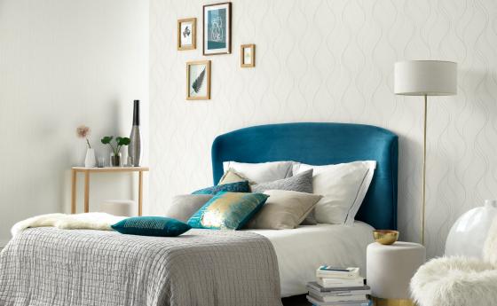 Wandgestaltung Schlafzimmer, weiße Vliestapete mit Wellenmuster, Bett blau, Dekokissen, Lampe