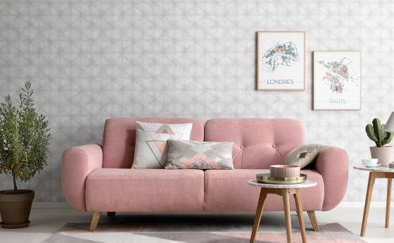 Vliestapete mit schwerelosem Grafikmuster in einem hellen Grau. Im Vordergrund rosanes Sofa im Scandi-Styl.